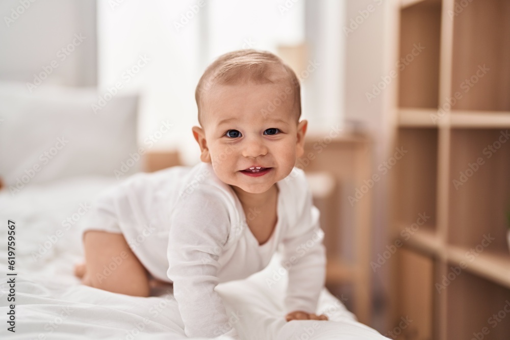 Adorable toddler smiling confident crawling on bed at bedroom Adorable toddler smiling confident crawling on bed at bedroom