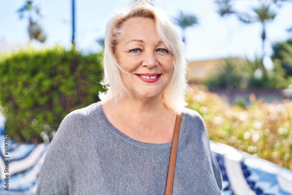 Middle age blonde woman smiling confident standing at park Middle age blonde woman smiling confident standing at park