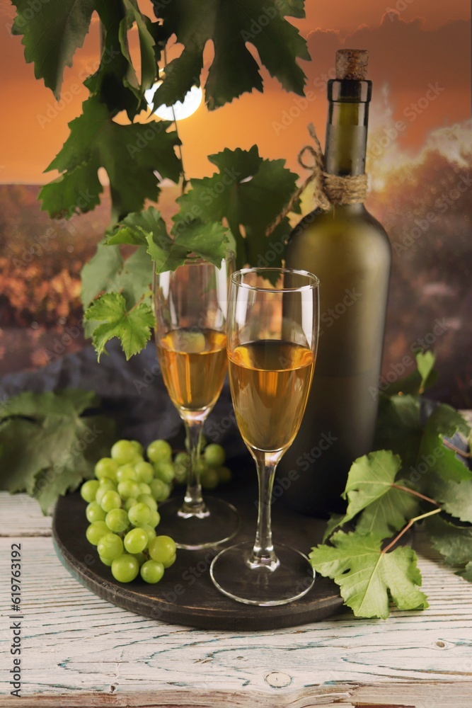 Wine glasses, bunches of grapes on a wooden table, on the background of the sunset, romantic atmosphere, harvest, organic natural products