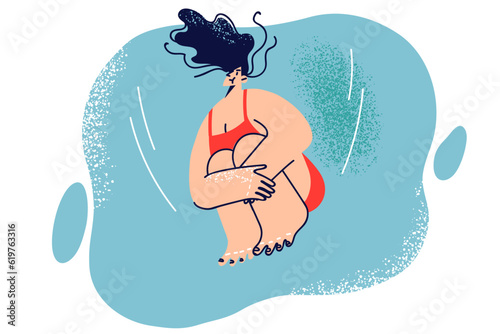 Woman dives into water and holds breath jumping from springboard and diving into deep pool