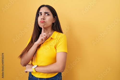 Fotografie Young arab woman standing over yellow background thinking concentrated about dou