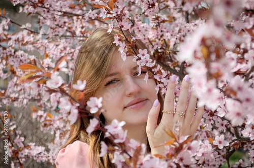 Portrait of a girl in spring flowers with long hair