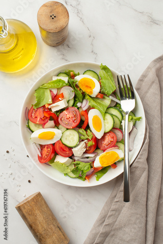 salad of fresh vegetables and greens with egg and feta cheese