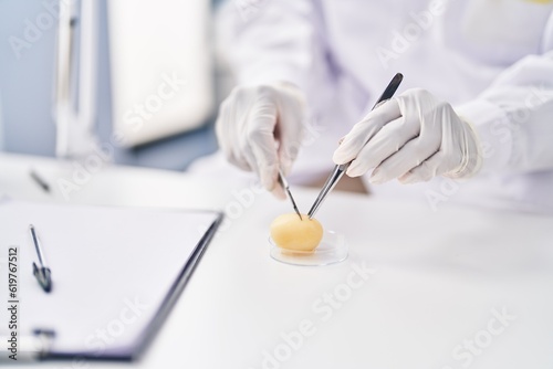 African american woman wearing scientist uniform analysing sample at laboratory