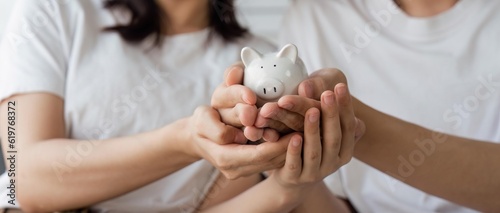 Happy asian young couple love calculate and putting coin in piggy bank for saving money to buy real estate for new home. Business finance, deposit with banking for financial planning future together