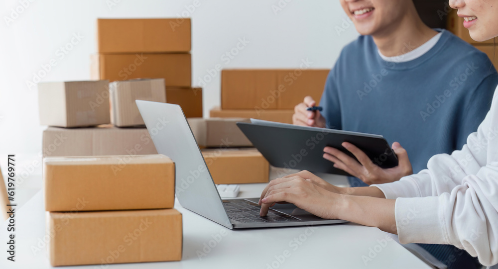 Happy couple people packing parcel boxes, couple lover checking order online on laptop at home Happy couple people packing parcel boxes, couple lover checking order online on laptop at home