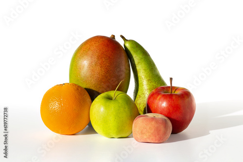 fresh fruit group - apple green and red, pear, mango and orange, lie on a white table, isolated