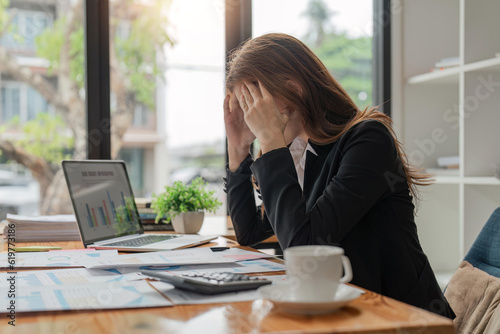 Stress, anxiety and burnout with a business woman at work using a laptop while suffering from a headache