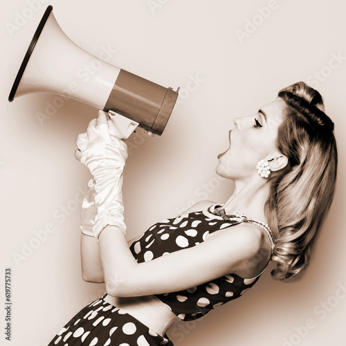Woman hold mega phone megaphone, shout advertising offer. Girl wear pin up style dress in polka dot yelling loudspeaker. Brown toned monochrome b&w photo. Female model in retro vintage studio photo