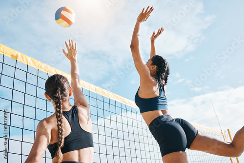 Woman, volleyball and teamwork by net for sports game, match or competition together in the outdoors. Female person, friends or team playing volley reaching for ball in fitness or athletics in nature photo