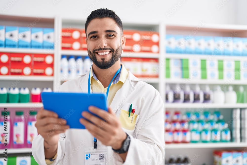 Young arab man pharmacist using touchpad working at pharmacy Young arab man pharmacist using touchpad working at pharmacy
