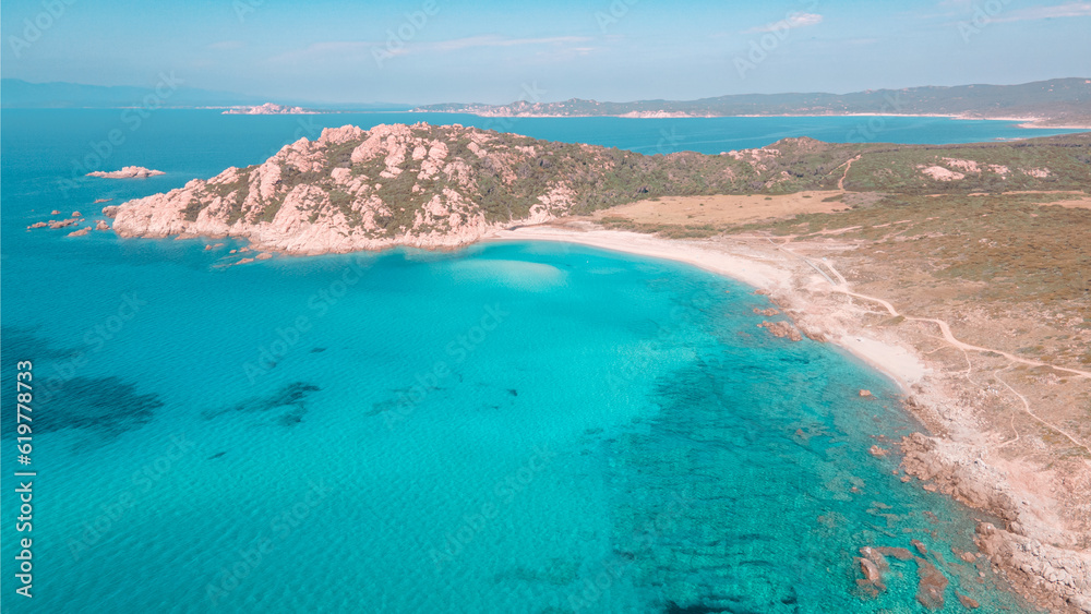 Aerial view from the drone of the Monti Russu promontory in Aglientu in Northern Sardinia, the emerald blue sea contrasts with the pink granite promontory and the surrounding Mediterranean scrub. 