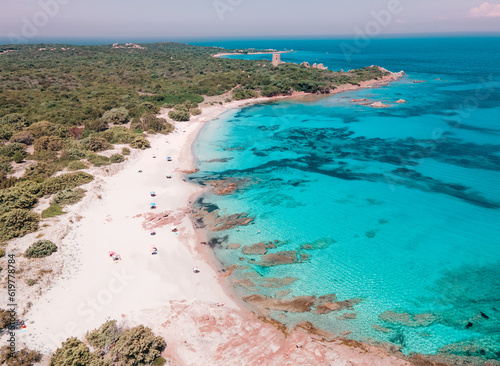 Panorama aereo drone sulla spiaggia di Vignola Mare ad Aglientu, in Sardegna. Sullo sfondo la torre omonima, i colori azzurri dell'acqua contrastano con quelli della macchia mediterranea.