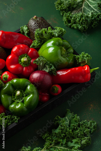 assorted red and green vegetables tomatoes, bell peppers, kale avocado