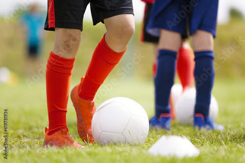 Soccer Players Kicking Classic White Soccer Balls on Training Session. Youth Football Background. Young Boy Wearing Soccer Cleats and Soccer Socks.