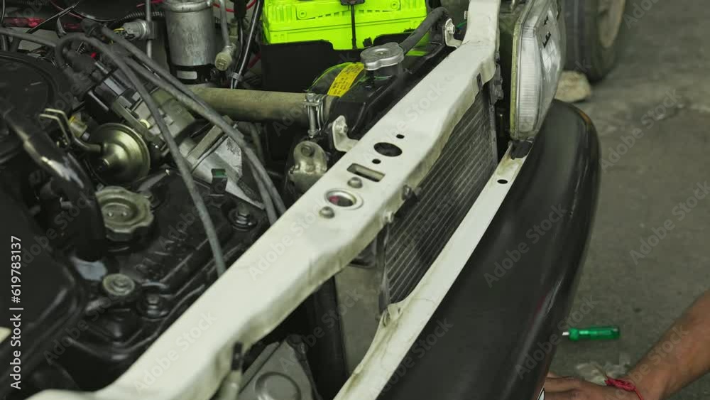 Closeup of a man wiping or cleaning the bumper of the car during service