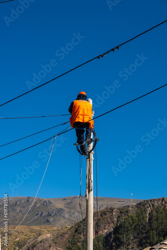 electrician doing repair work on public lighting poles in peru