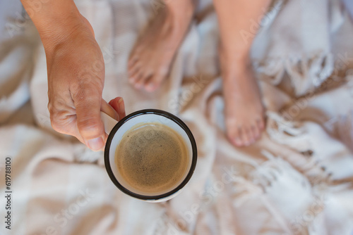 taza de café con espuma en manos de una mujer, vista cenital photo