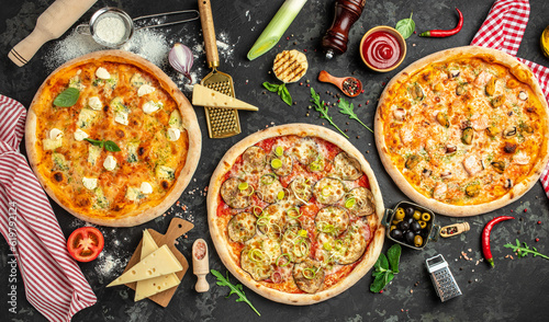 three different types of pizza on a dark background, Fast food lunch. top view. place for text