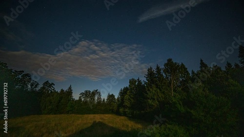 Night time lapse with sky and noctilucent clouds over forest. photo