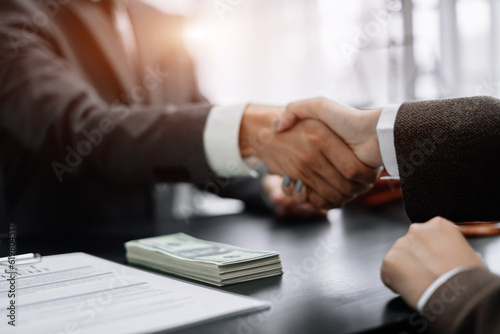 Lawyer shaking hands with client after discussing final contract agreement.