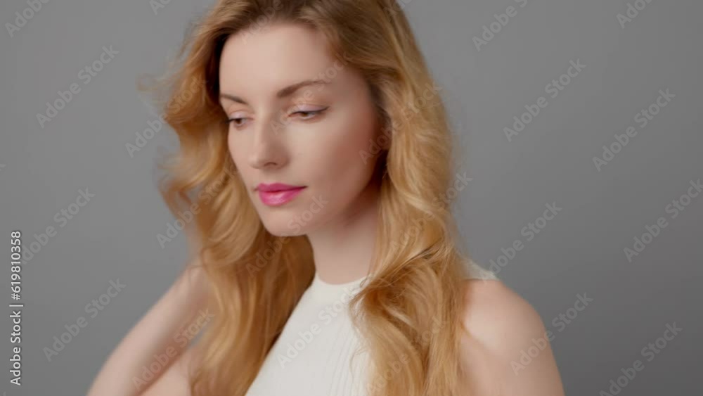 Fashionable woman with smiling face looking at camera for confidence, vogue, advert. Glamor blonde lady posing, pride emotion, trend stylish hairstyle, makeup, fashion pastel outfit in studio on grey Fashionable woman with smiling face looking at camera for confidence, vogue, advert. Glamor blonde lady posing, pride emotion, trend stylish hairstyle, makeup, fashion pastel outfit in studio on grey