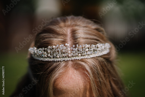 A beautiful young woman, her features blurred in the closeup, wears a luxurious tiara, adding an air of elegance to her overall appearance