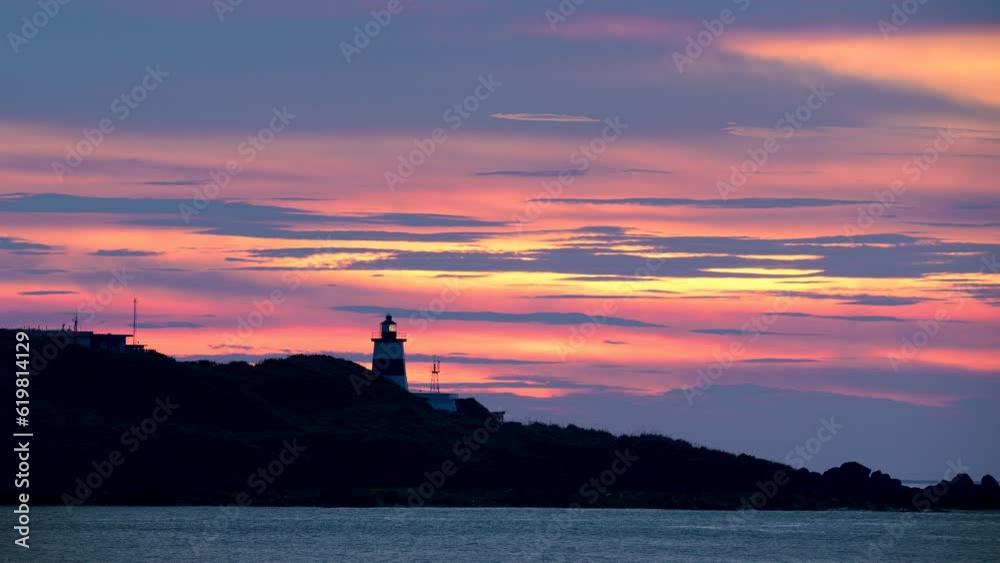 Clouds resemble tiger stripes. The sun is obscured by clouds and appears hazy. Fugui Cape Lighthouse is known for its sunset shots and tourist attractions. Clouds resemble tiger stripes. The sun is obscured by clouds and appears hazy. Fugui Cape Lighthouse is known for its sunset shots and tourist attractions.