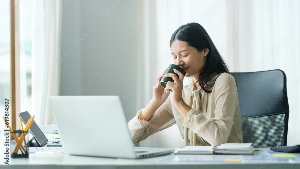Attractive young businesswoman drinking coffee and working at modern office. Attractive young businesswoman drinking coffee and working at modern office.