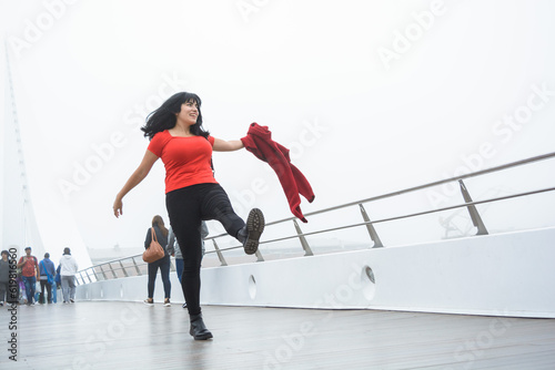 young tourist woman walking and jumping happily on the Puente De La Mujer in Buenos Aires.