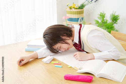 自宅で勉強中に居眠りする女子高生