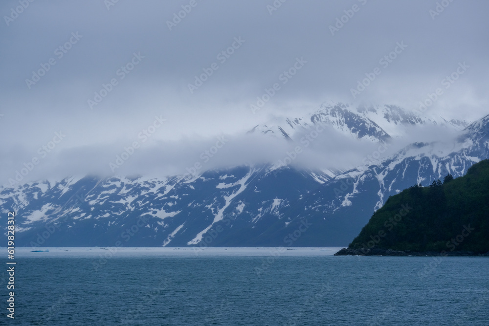 Cruise to Hubbard Glacier Bay in Alaska with floating ice bergs and drift ice floes on ocean water surface surrounded by snow capped mountains and wildlife wild nature scenery Last Frontier adventure	