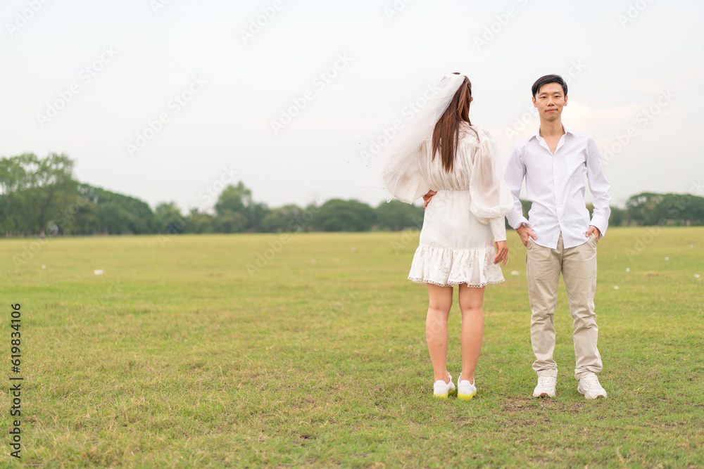 Happy young Asian couple in bride and groom clothing Happy young Asian couple in bride and groom clothing