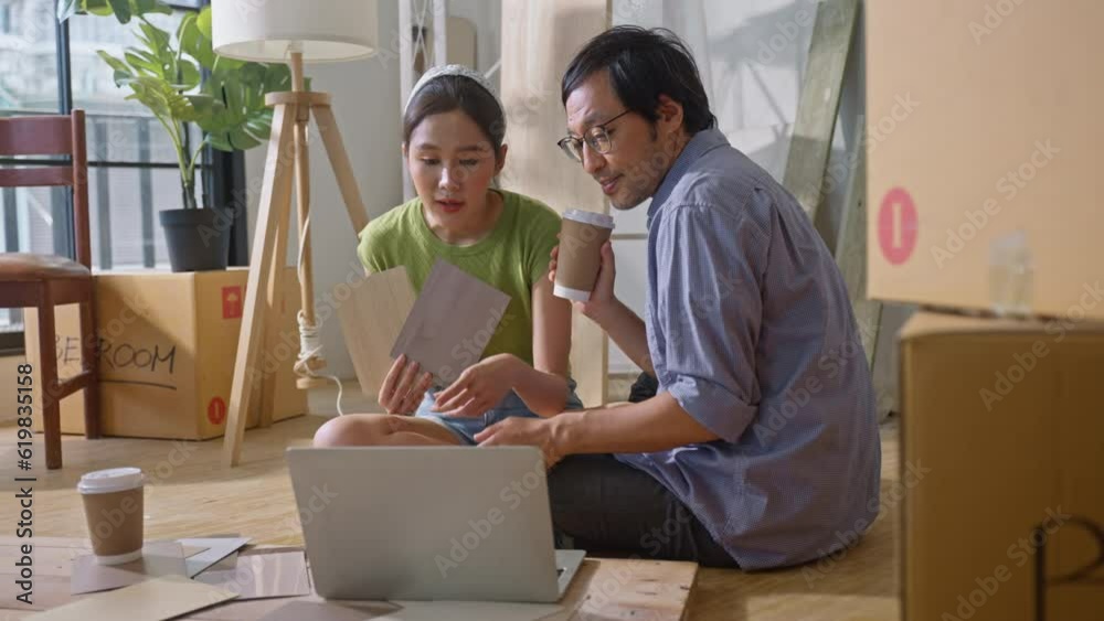 Asian couple of home owners discussing new renovate home,wood samples,moving box,interior design improvement,new design for new home.asian chooses a sample floor for his new apartment Asian couple of home owners discussing new renovate home,wood samples,moving box,interior design improvement,new design for new home.asian chooses a sample floor for his new apartment