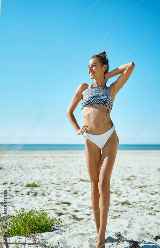 Stunning and tanned woman with long legs enjoying the sun on paradise beach with white sand. Beautiful tan, she, hair removal, smoothing skin, and body care concept Stunning and tanned woman with long legs enjoying the sun on paradise beach with white sand. Beautiful tan, she, hair removal, smoothing skin, and body care concept