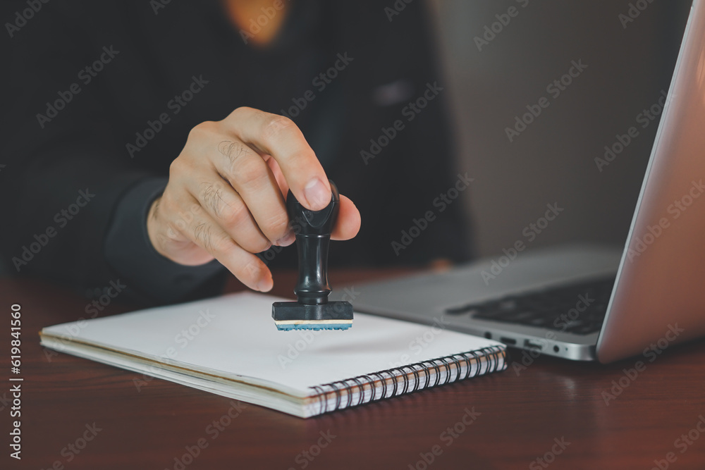 Close-up Of A Person's Hand Stamping With Approved Stamp On Text Approved Document At Desk.
 - obrazy, fototapety, plakaty 