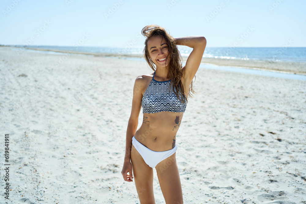 Outdoor fashion shot of gorgeous sexy woman with perfect slim body in stylish swimwear resting on paradise white beach at sunny day Outdoor fashion shot of gorgeous sexy woman with perfect slim body in stylish swimwear resting on paradise white beach at sunny day