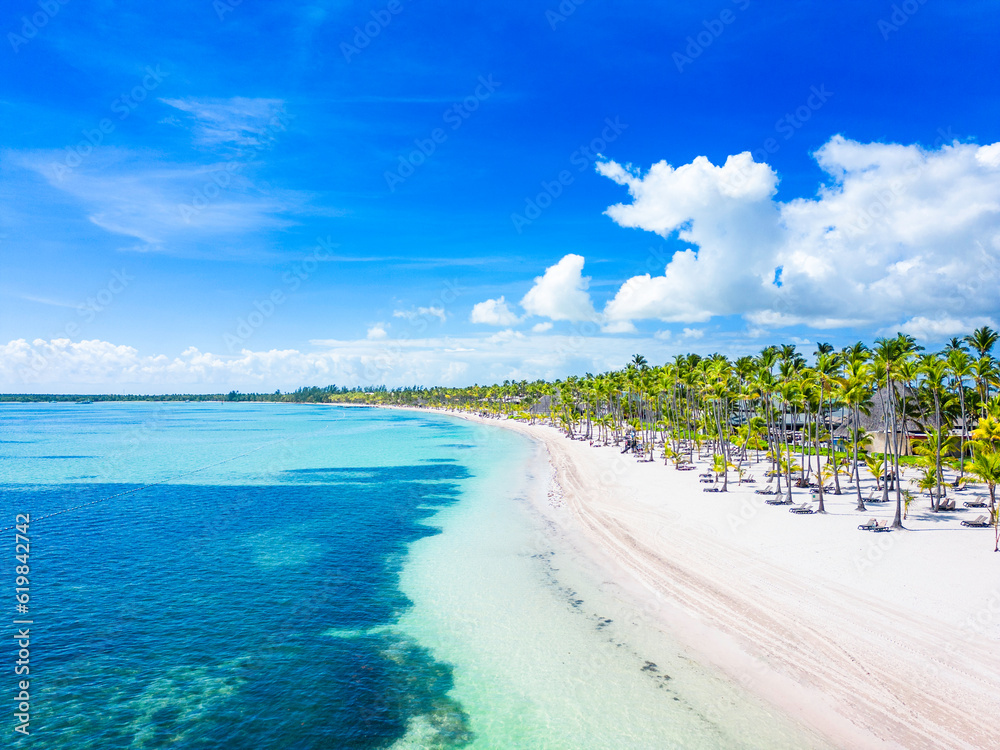 Beautiful tropical beach with white sand and palm trees. Turquoise water and blue sky. Summer vacation in the all inclusive resort and hotel - obrazy, fototapety, plakaty 