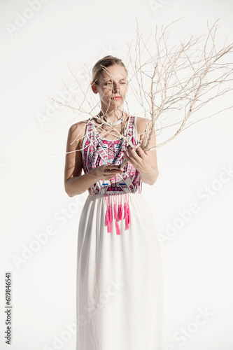 Photograph of a beautiful woman creating shadows on her face using a dry desert plant. 