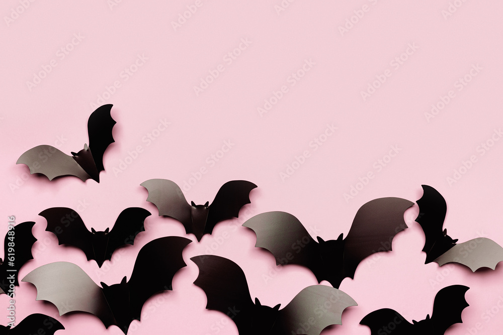 Minimal flat lay with black bats as halloween party background. Frame from paper decorations flying bats on pink background for holiday card or invitation. Aesthetic halloween pattern Minimal flat lay with black bats as halloween party background. Frame from paper decorations flying bats on pink background for holiday card or invitation. Aesthetic halloween pattern