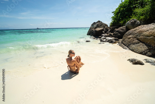 Beautiful woman sunbathing and relaxing at amazing tropical beach in a sunny summer day. Koh Lipe island