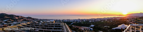 Beautiful sunset over the mediterranean sea and the city of Alanya in Turkey. The sunset is reflected in the water and slightly illuminating the city. Beautiful landscape. © Анатолий Савицкий