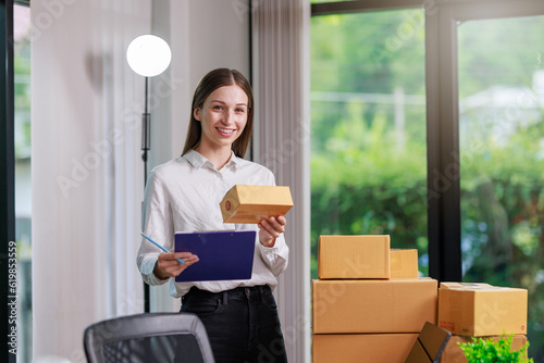 Concept of parcel delivery and selling online,Retailer writing customer detail on parcel box and prepare to send product parcel to the customer