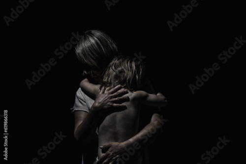 a girl hugs a child on a black background © jahorimine