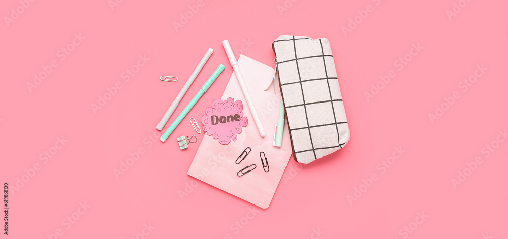 Sticky note with word DONE and stationery on pink background Sticky note with word DONE and stationery on pink background