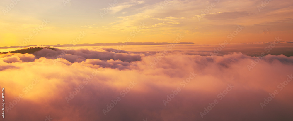 Aerial view of Morning sunrise above the mountains with mist around , Mountains fog and morning sun in winter at Pha Mo Edang ,Sisaket province,Thailand.red light.