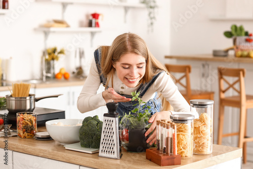 Happy young woman smelling ...