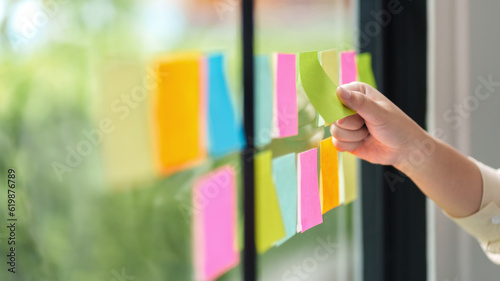 Creative startup putting ideas on sticky note at modern office..