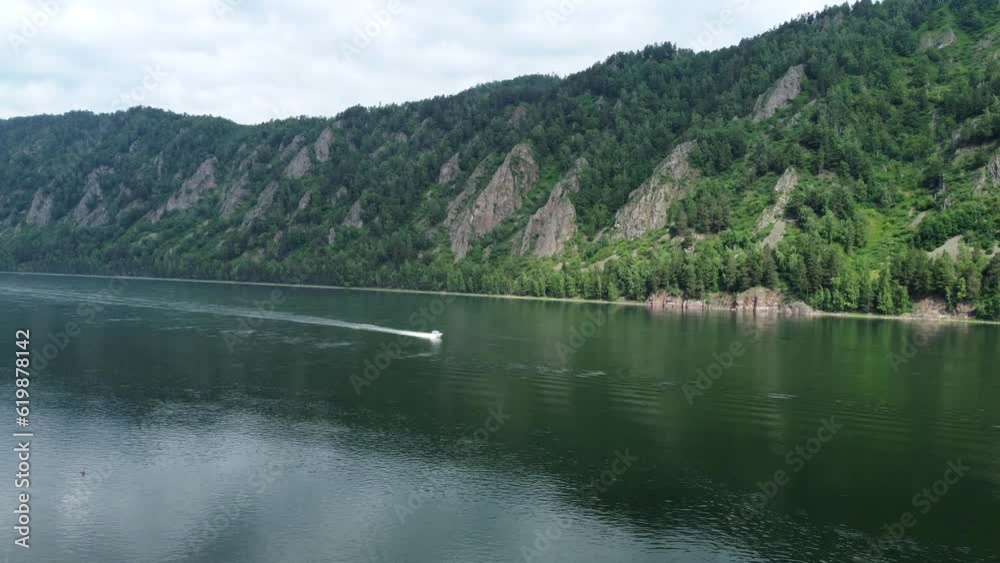 Aerial view of mountain hills covered with dense green woods on summer day. River or lake at front. Aerial view of mountain hills covered with dense green woods on summer day. River or lake at front.