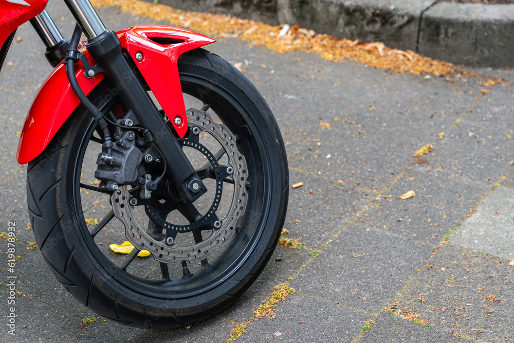 Front wheel of a red motorcycle with disc brakes. Close up.